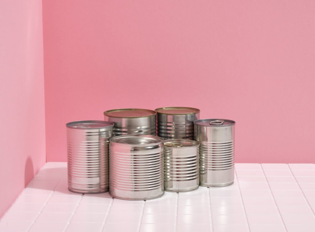 tin cans kept on surface in pink background